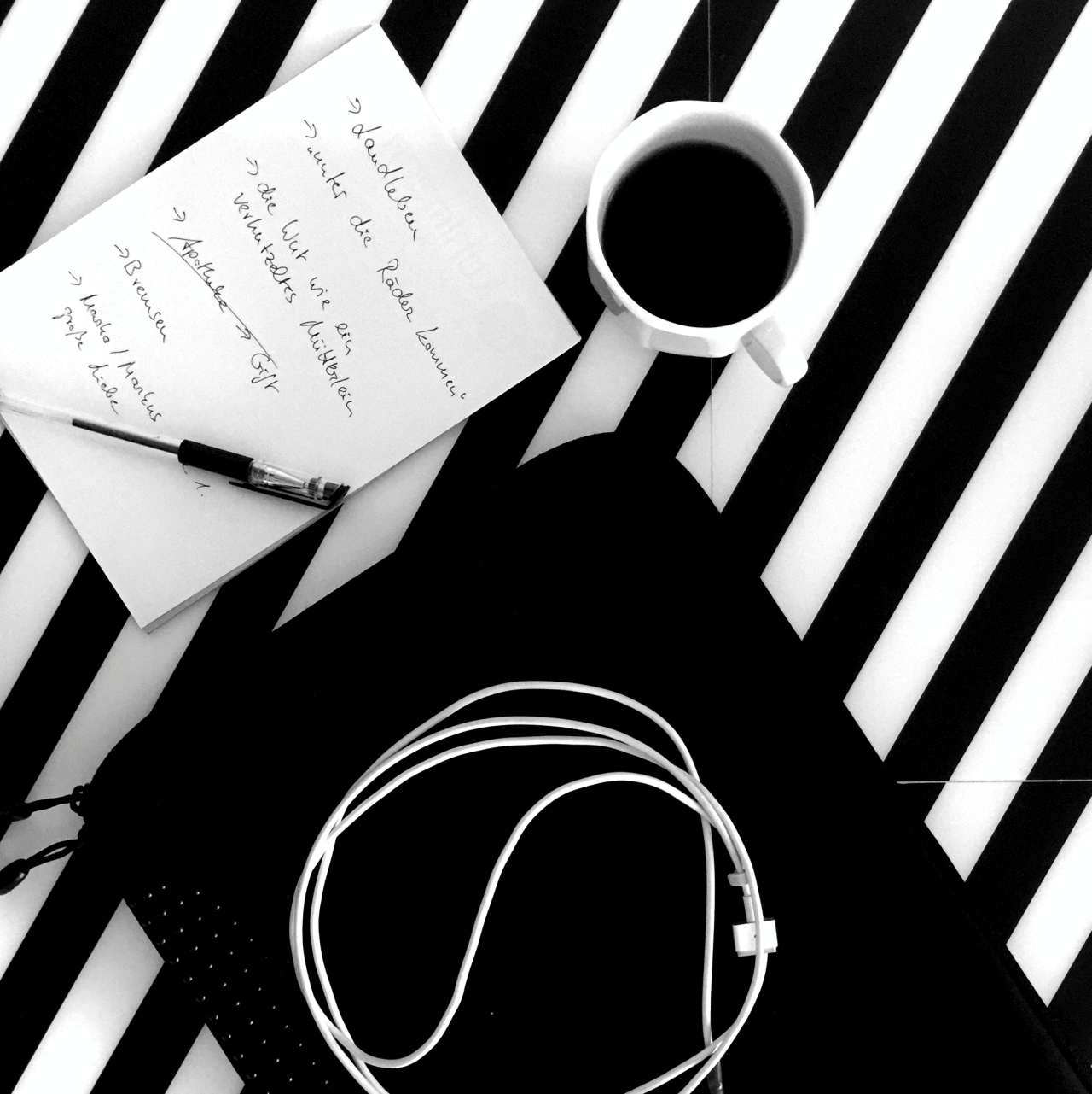 Schwarz-weißes Muster mit Kaffee und Ladekabel