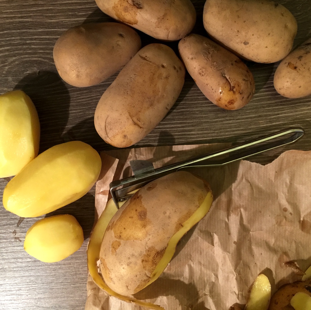 Einige Kartoffeln, davon 3 geschält und eine halb geschält