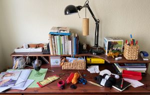 Ein Schreibtisch mit Schreibzeug und Häkelzeug