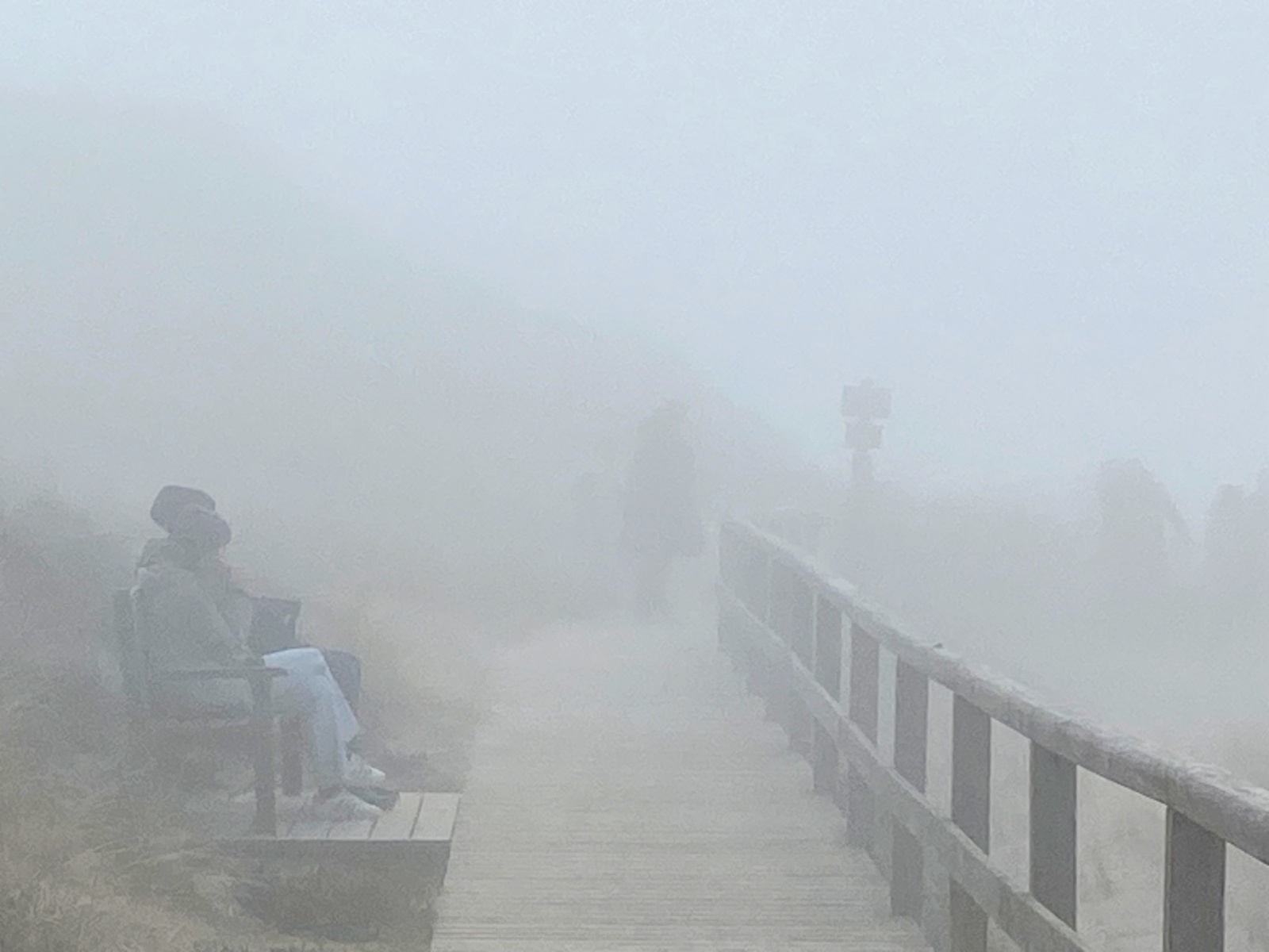 Leute sitzen auf einer Bank im dichten Nebel
