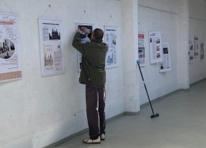 Thomas Schmitt-Schech bringt ein Plakat an