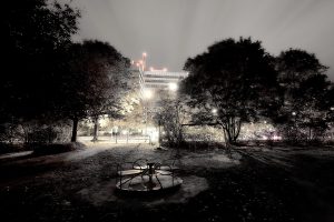 Ein Spielplatz bei Nacht im Mystery Month - unheimlich beleuchtet von umstehenden Häusern