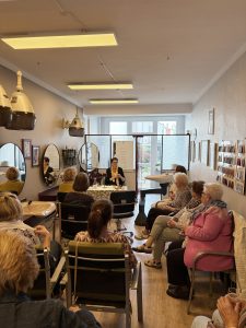 Kundinnen im Friseursalon lauschen einer Lesung